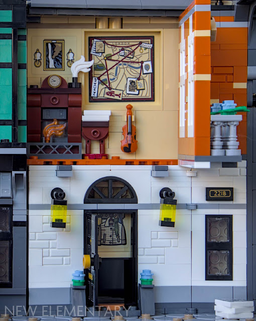 221b Baker Street from the sherlock lego book nook set. The front door is open, and the front wall of the upper floor has been hinged open forwards, revealing silhouetted furniture and wall pictures