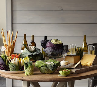 A heavily laden Thanksgiving table where the serving dishes are vegetables and all the food is natural.