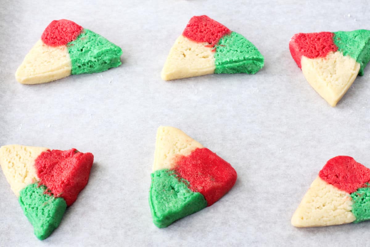 Red, White, and green polvorones shaped dough on a baking sheet.