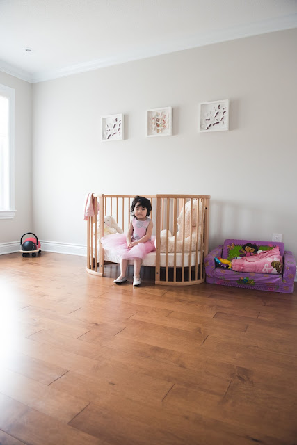 Photo of little girl sitting in her bed in her room waiting for the party to begin. Photo taken by Melanie Mathieu Photography during lifestyle photography session.