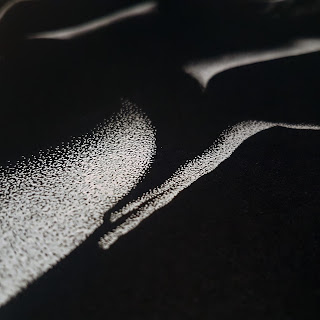 Close up of pointillism artistic nude Drawing bodyscape of nude figure in black and white shadows on paper, made out of thousands of tiny white dots.