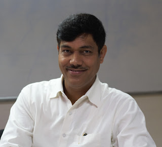Image of Mr. Subhash Chandra Vashishth in a white shirt, smiling.