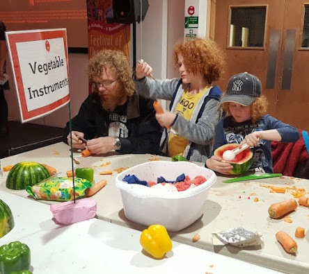 2 boys and father making instruments from vegetables and all engrossed in their carving