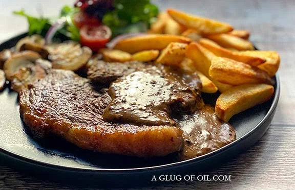 Steak and chips with peppercorn sauce.