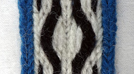 A section of tablet woven band with loose threads on the surface