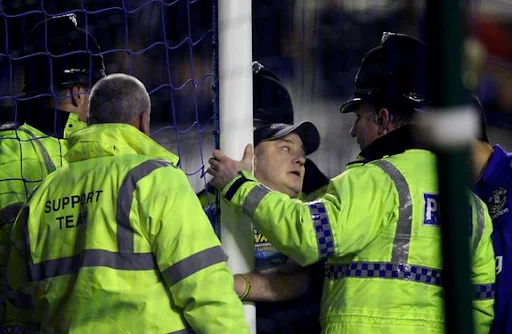 Police speak to a man who handcuffed himself to the goalpost