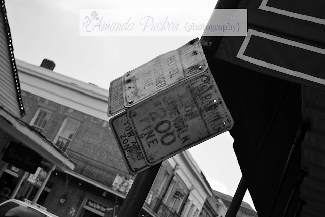 Black and white of broken no parking sign on Bourbon Street