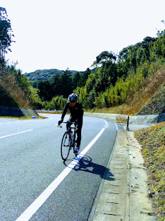 坂道で必死で自転車を漕いでいる旦那