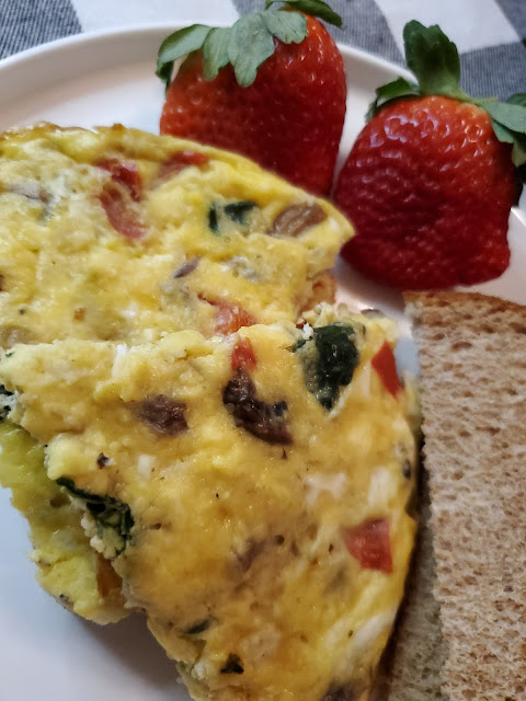 Veggie Frittata Wedges with fruit and toast on a white plate