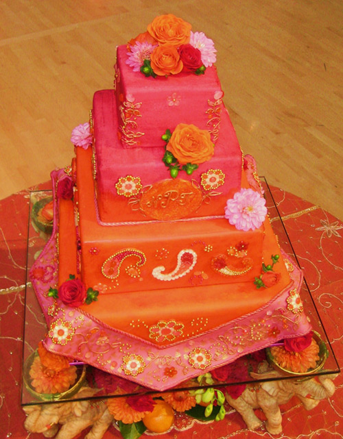 Orange and pink three tier wedding cake decorated with pink daisies original