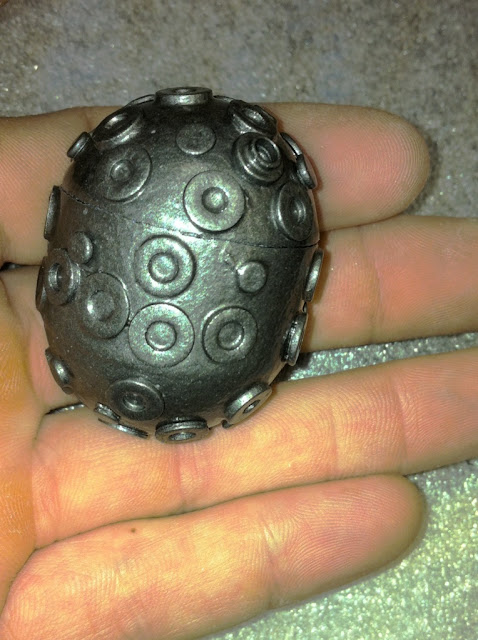 In the open fingers of a left hand sits the Starball positive for the Mini-Zeiss Model.  It has many small washers and nail heads attached to it now to mimic the lenses of the real Zeiss.  It has also been painted with Hammerite which gives it a metallic silver appearance.  It is about 1.5 inches long and 1 inch in diameter.