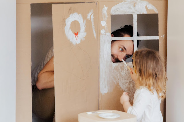 a-little-girl-and-her-dad-painting-a-cardboard-house