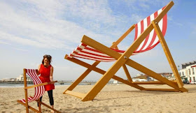 Giant striped chaise lounge on UK beach