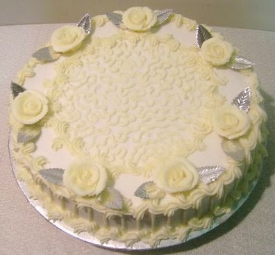 A simple onetier pale yellow ivory and silver birthday cake