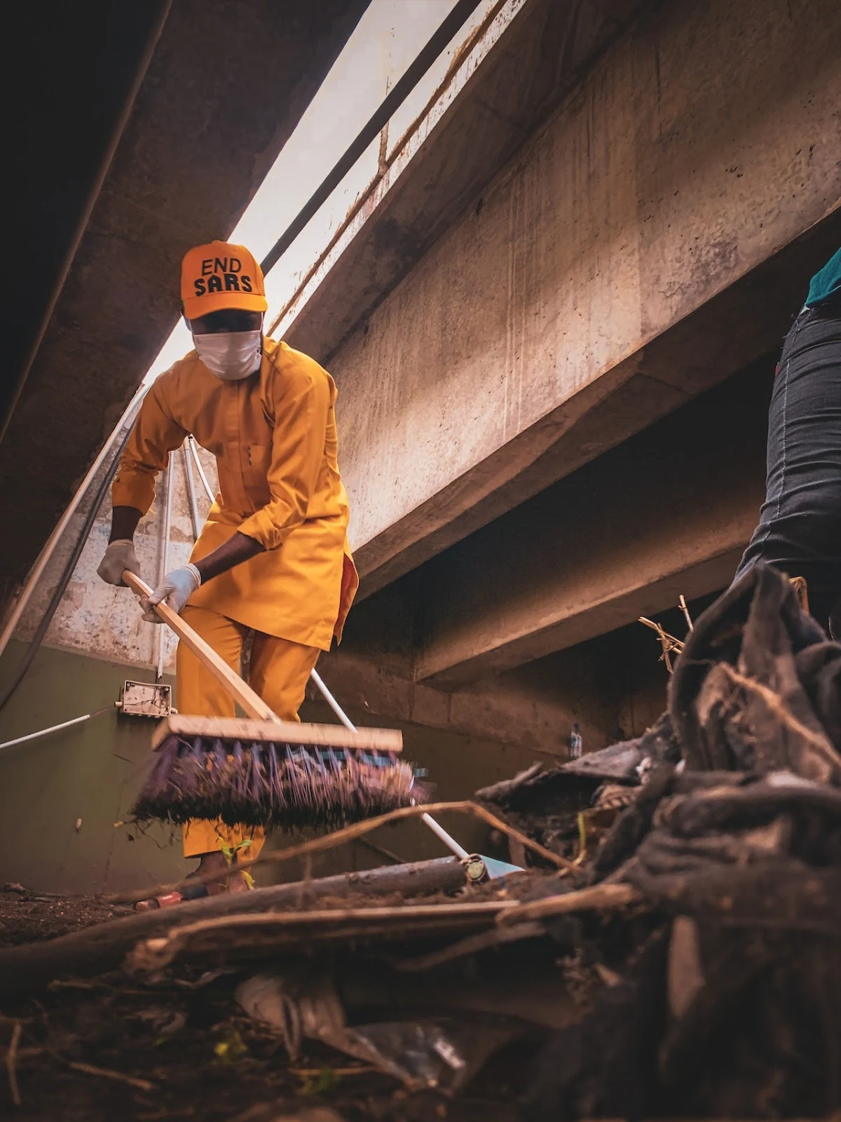 man in uniform cleaning dirt with broom