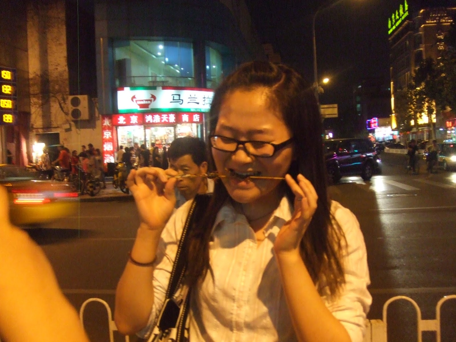 Chinesin isst Skorpion am Abend in der Stadt