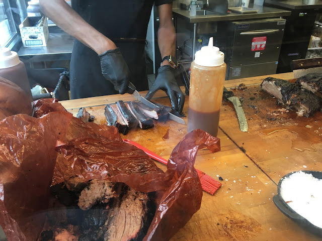 BBQ Ribs being cut behind the counter (Mighty Quinn's BBQ - Garden City NY)