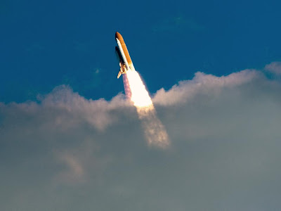 Space shuttle Atlantis breaks through the clouds during launch on its STS-129 mission