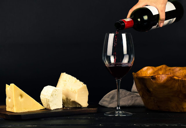Cheese and wine being poured into a glass