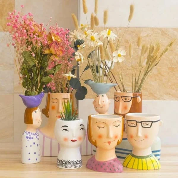 ceramic family character vases holding a floral arrangement in each one