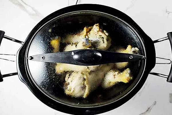 Slow cooker cilantro lime chicken cooking in the slow cooker with lid on