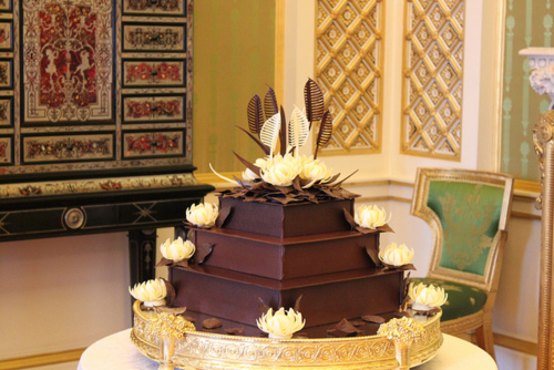 The flawless square cake rose up three tiers above its golden stand at the