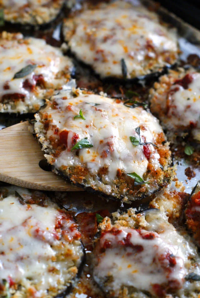 A piece of eggplant parmesan on a wooden spatula.