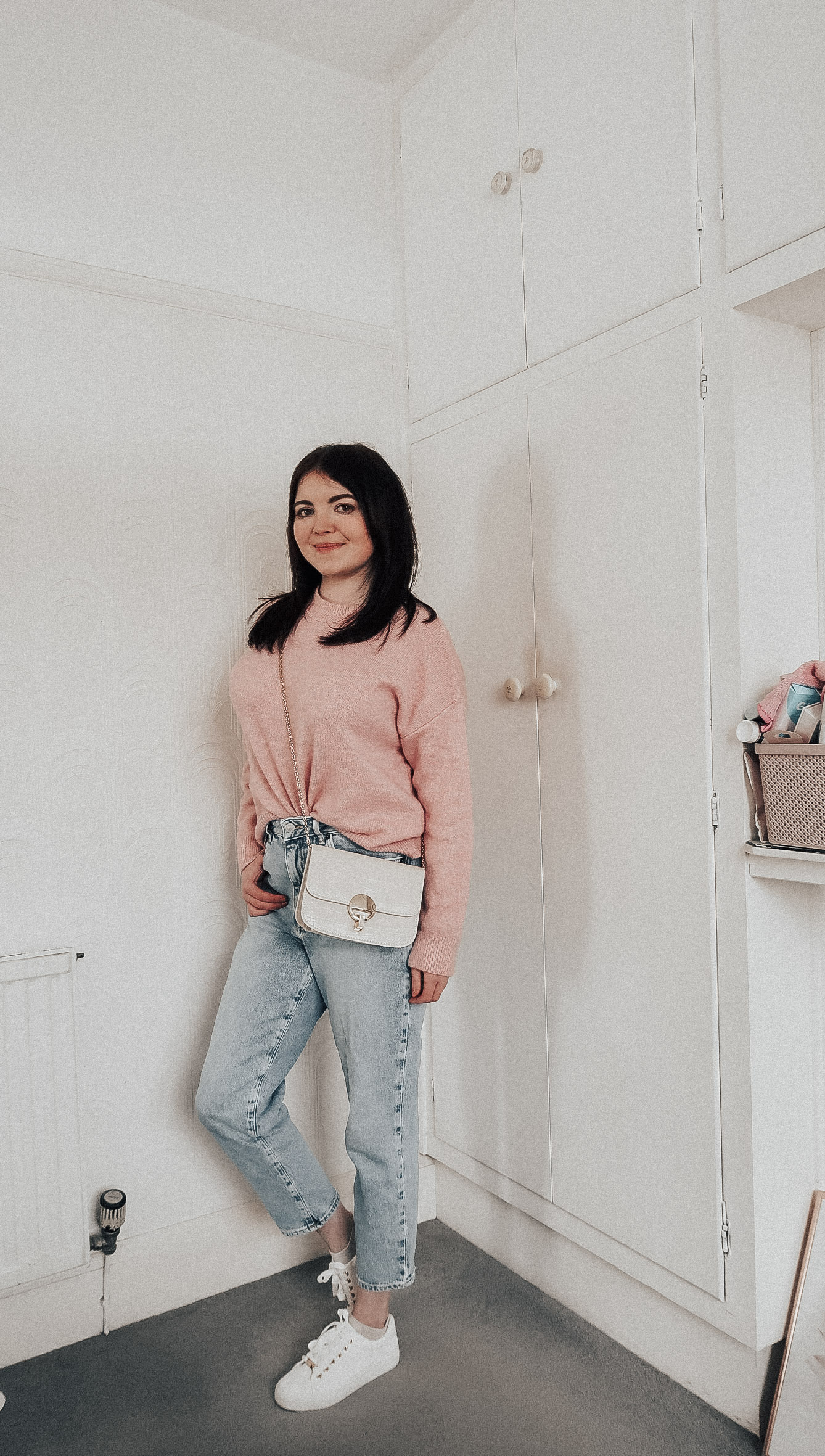 A woman wearing a pink jumper