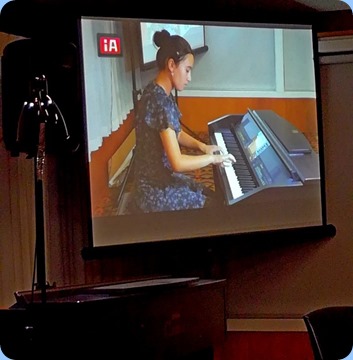Hana Tani played some Brahms, Bach and Haydn for us - well done! Hana showing-up on the big screen. Photo courtesy of Dennis Lyons.