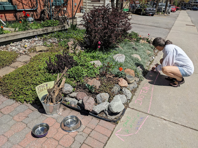 Manon giving chalking the sidewalk to inform the users of the library services