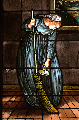 Stained glass window of woman with a broom and lamp looking for a lost coin