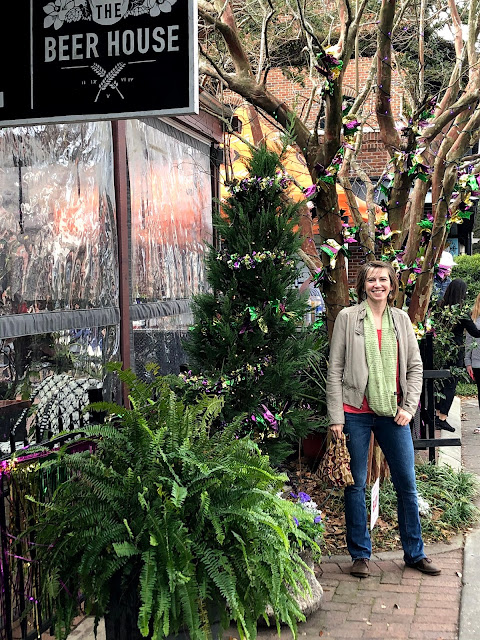 woman in front of Mardi Gras decorated tree