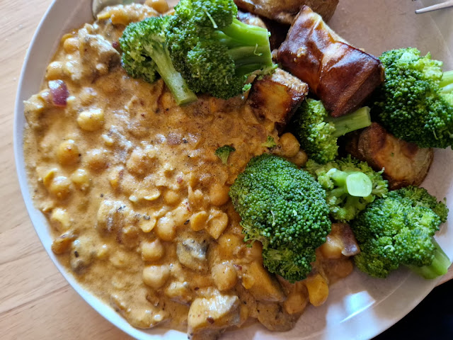 A photo of creamy chickpea curry with broccoli in a bowl