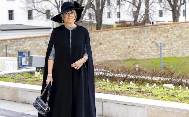 Queen Maxima wore a grey midi dress by Natan, and Philip Treacy hat. The Queen wore a navy cape coat by Valentino