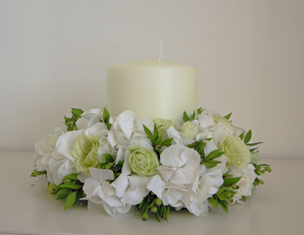 This design uses a chunky candle with white hydrangea green lisianthus and 