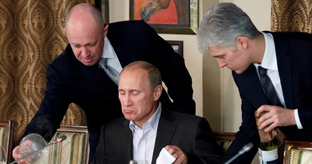 At a meal in 2011, Yevgeny Prigozhin is seen serving Vladimir Putin (center).