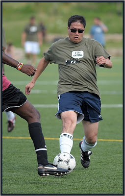 Man in sunglasses goes for soccer ball, Toronto photographer Robert Rafton