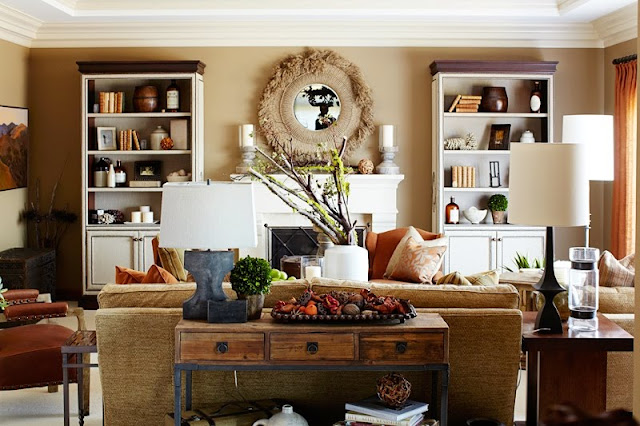 polished rustic  decor in a living room with a white modeled fireplace, white bookcase with white cabinets holding books and small keepsakes, a brown sofa with matching armchair and decorative wood table