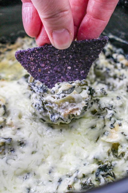 dip being scooped with a blue corn tortilla chip.