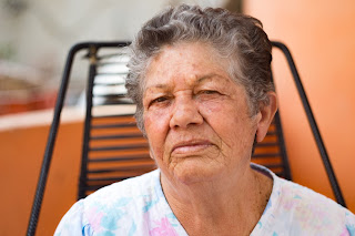 An elderly woman looking at the camera.