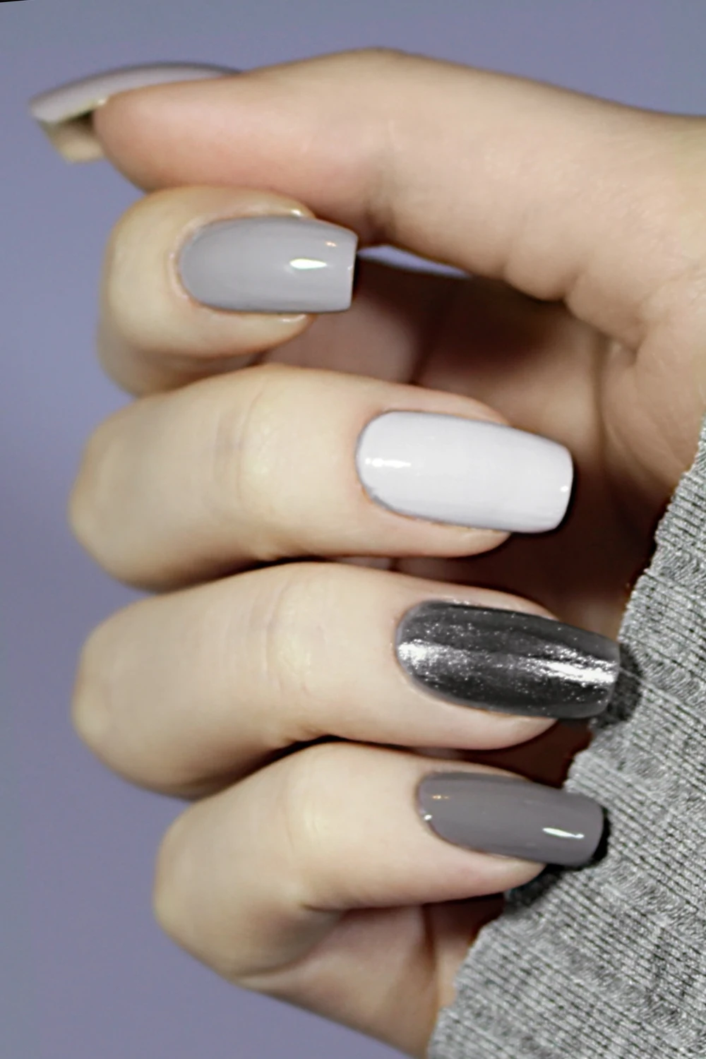 a close-up of a woman's hand with a minimal, Tonal Nail design