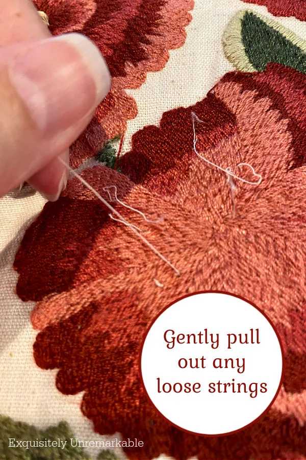 Gently removing old threads from embroidery