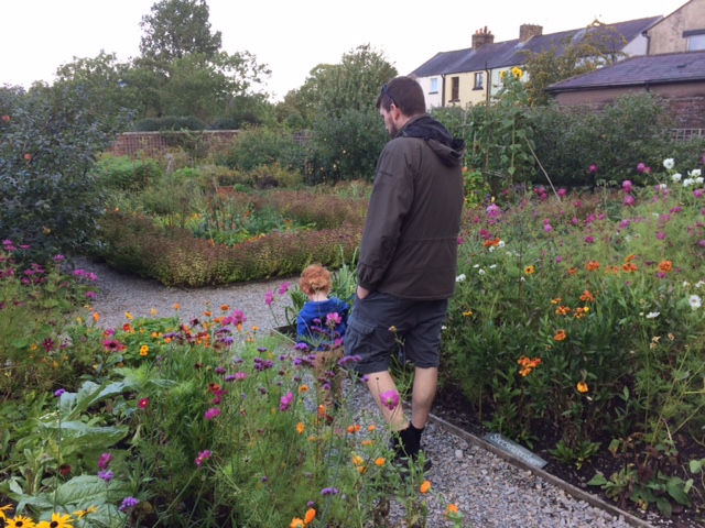 Daddy and toddler walking in the gardens