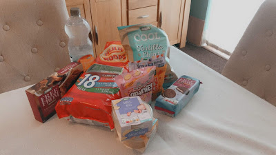 a pile of food including crisps, brownies, smarties and more