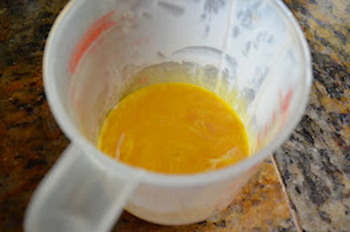 Egg Yolks whisked together in a measuring cup.