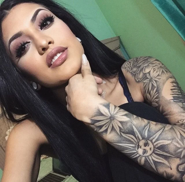 Mujer latina con tatuaje en el antebrazo de flores