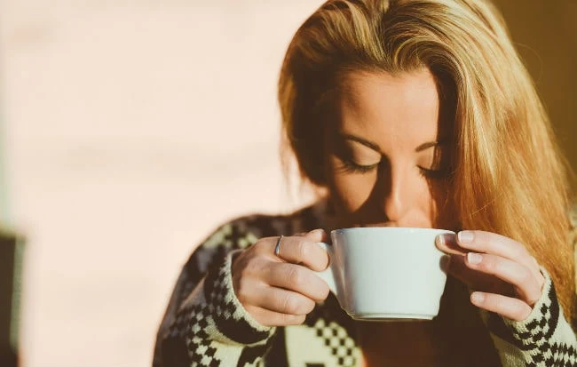 Donna che beve caffè: può ostacolare la gravidanza