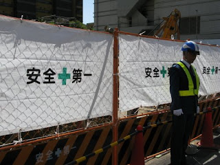 Security guard at accident site with Safety First slogans.