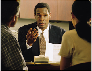 Photo of a black criminal defense lawyer talking with a couple about their case