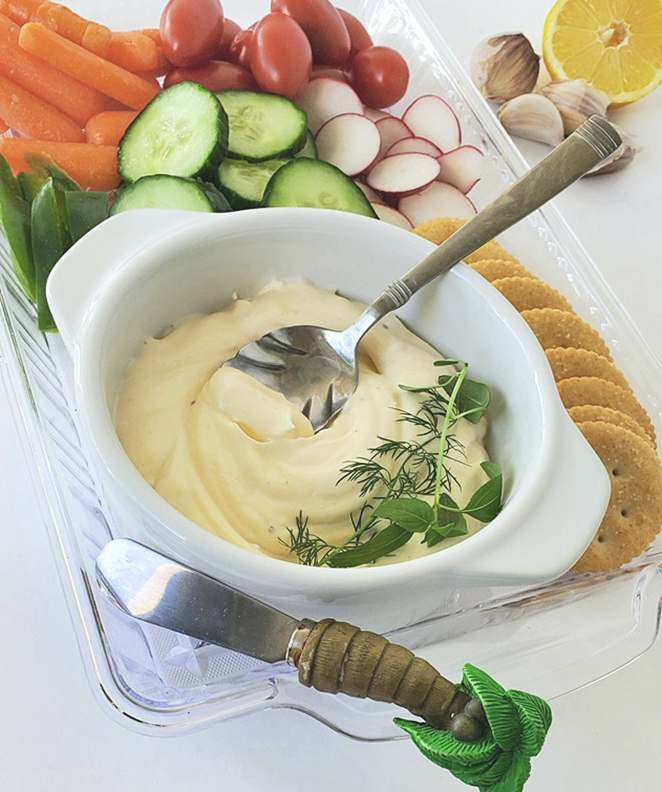 this is a creamy dip with roasted garlic served with assorted breads and vegetables